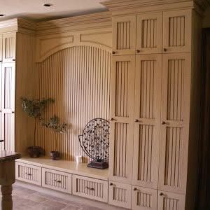 Large beadboard built-in storage and entertainment wall with open shelving above and panelled cabinet doors below